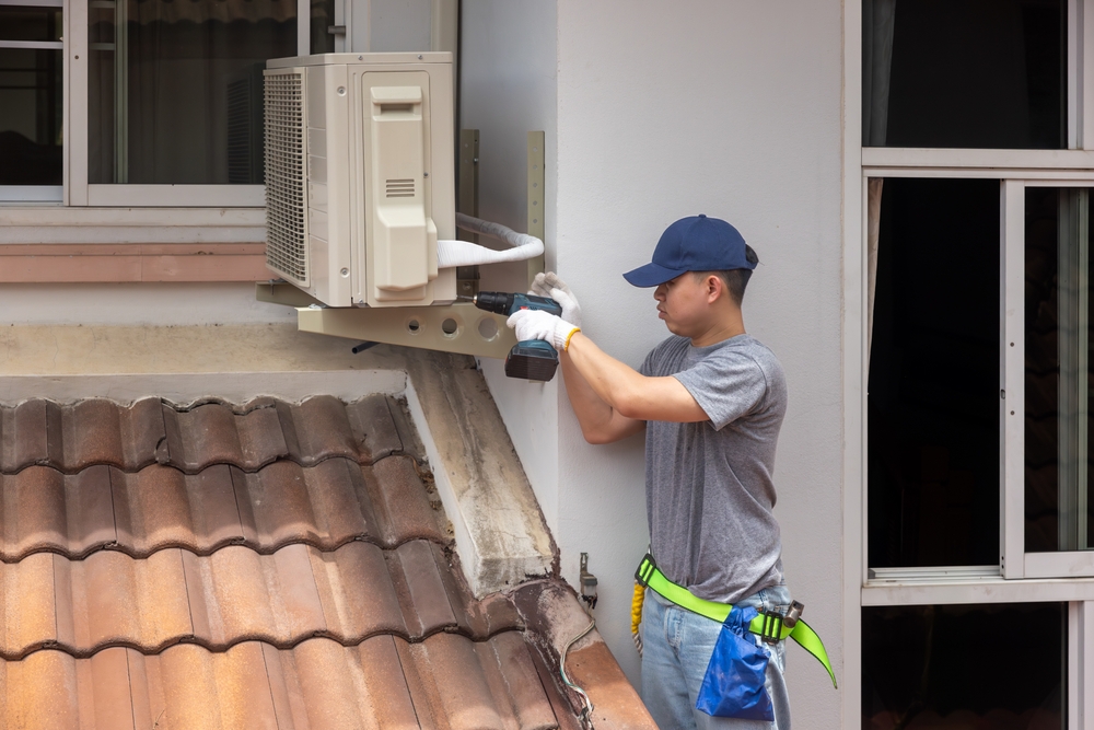 Technician,Fixing,Air,Conditioner,Unit,On,Outside,Wall.