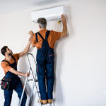 Two,Workers,In,Uniform,,Air,Conditioning,Masters,Using,Ladder,While