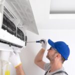 Service,Guy,Cleaning,And,Maintaining,Air,Condition,Unit.