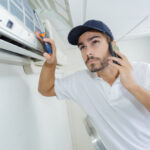 Young,Handyman,Repairing,Air,Conditioning,System,Calling,For,Help