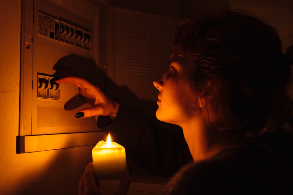 Young,Woman,With,Candles,In,Complete,Darkness,Examines,Fuse,Box