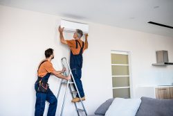 Two,Workers,In,Uniform,,Air,Conditioning,Masters,Using,Ladder,While