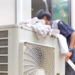 Selective,Focus,Of,Air,Conditioner,Compressor,With,Blurred,Technician,Man