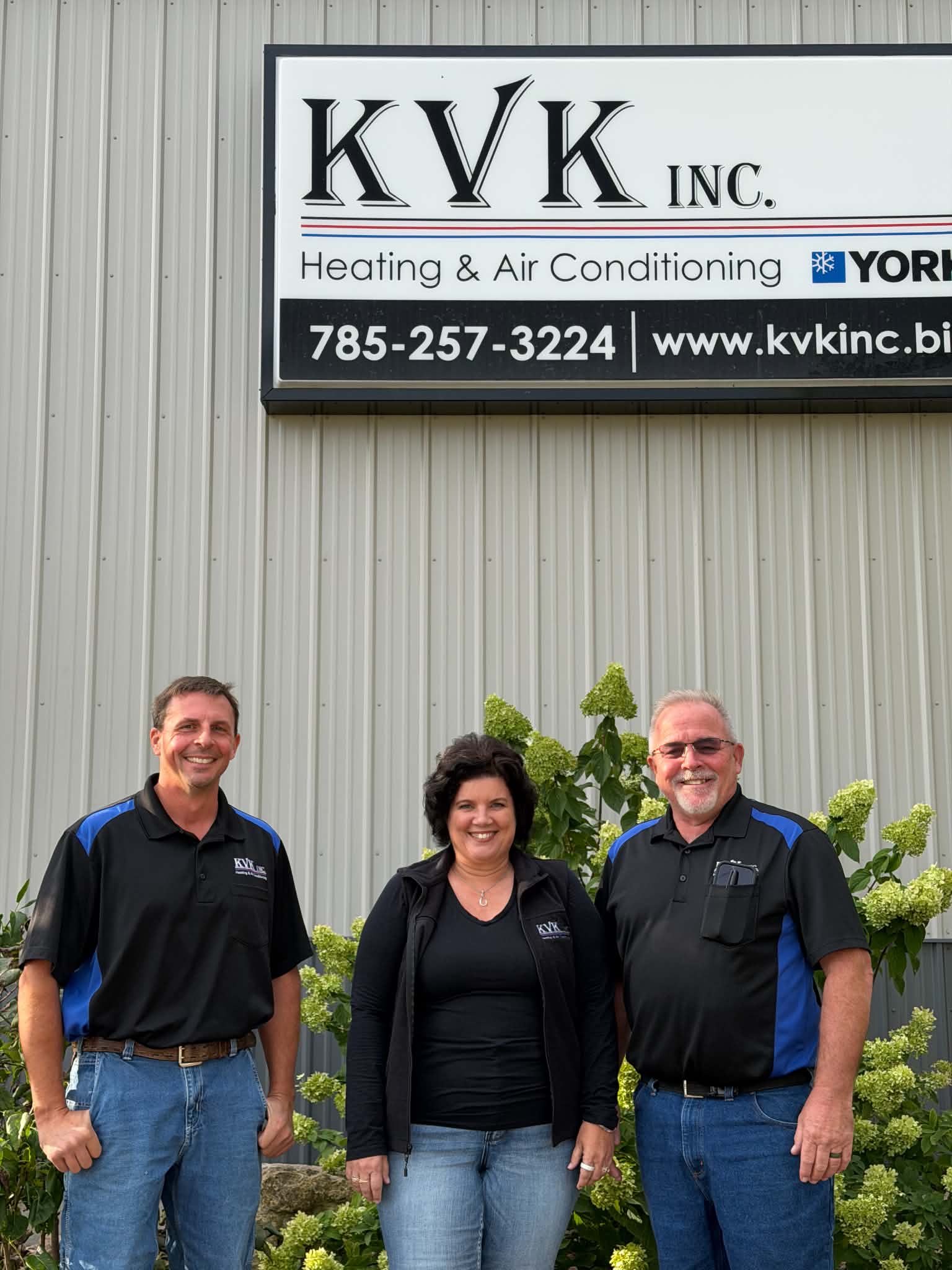 KVK Inc. team in front of the company sign